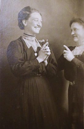Two women in vintage clothing posing for a studio portrait.