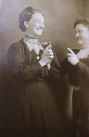 Two women in vintage clothing posing for a studio portrait.