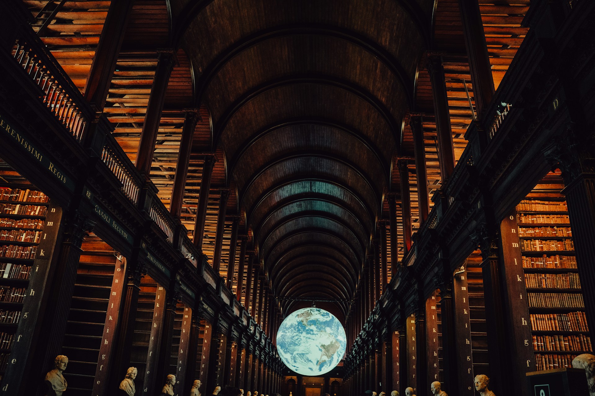 Grand library interior with a glowing globe