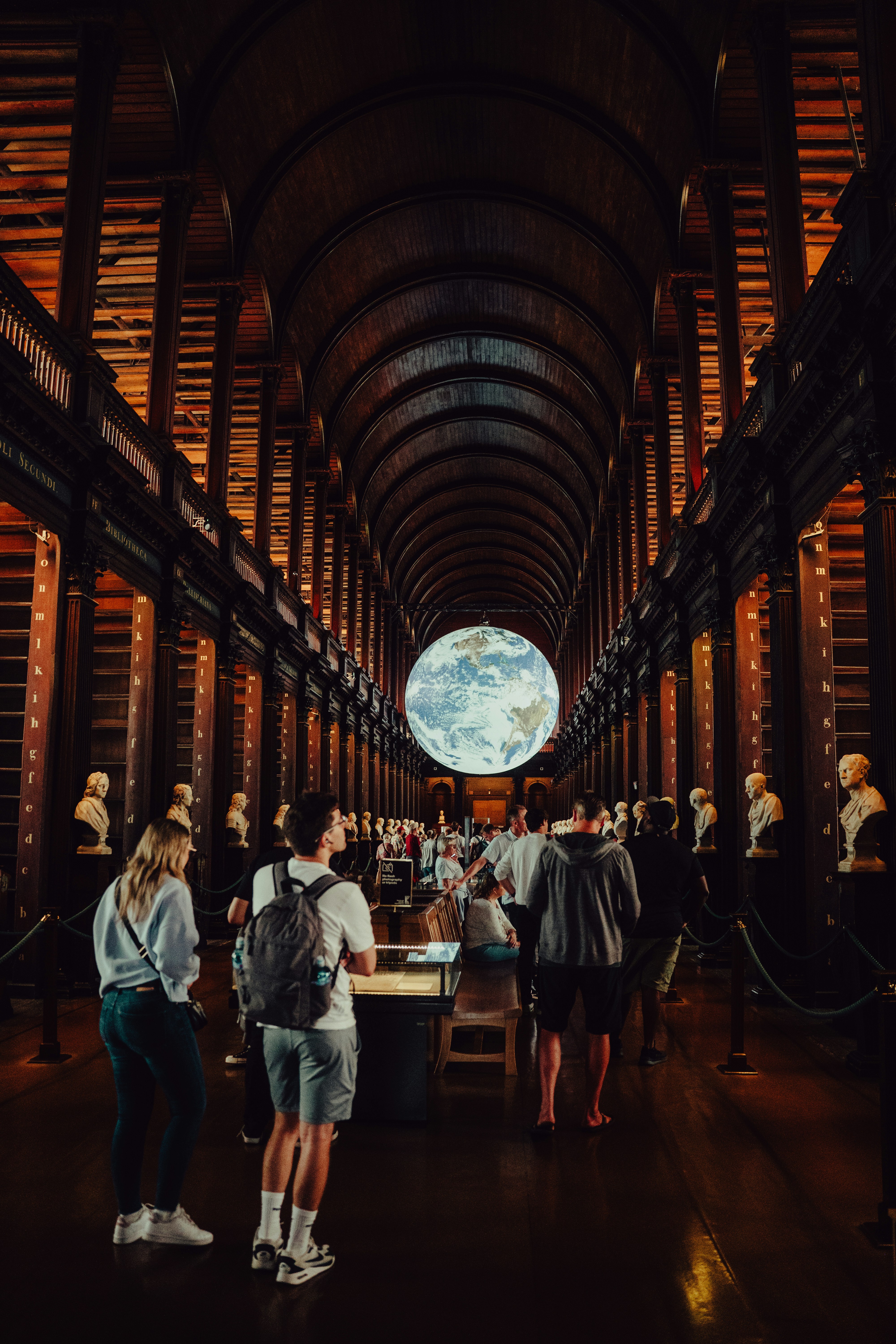People admire a large globe in a grand library