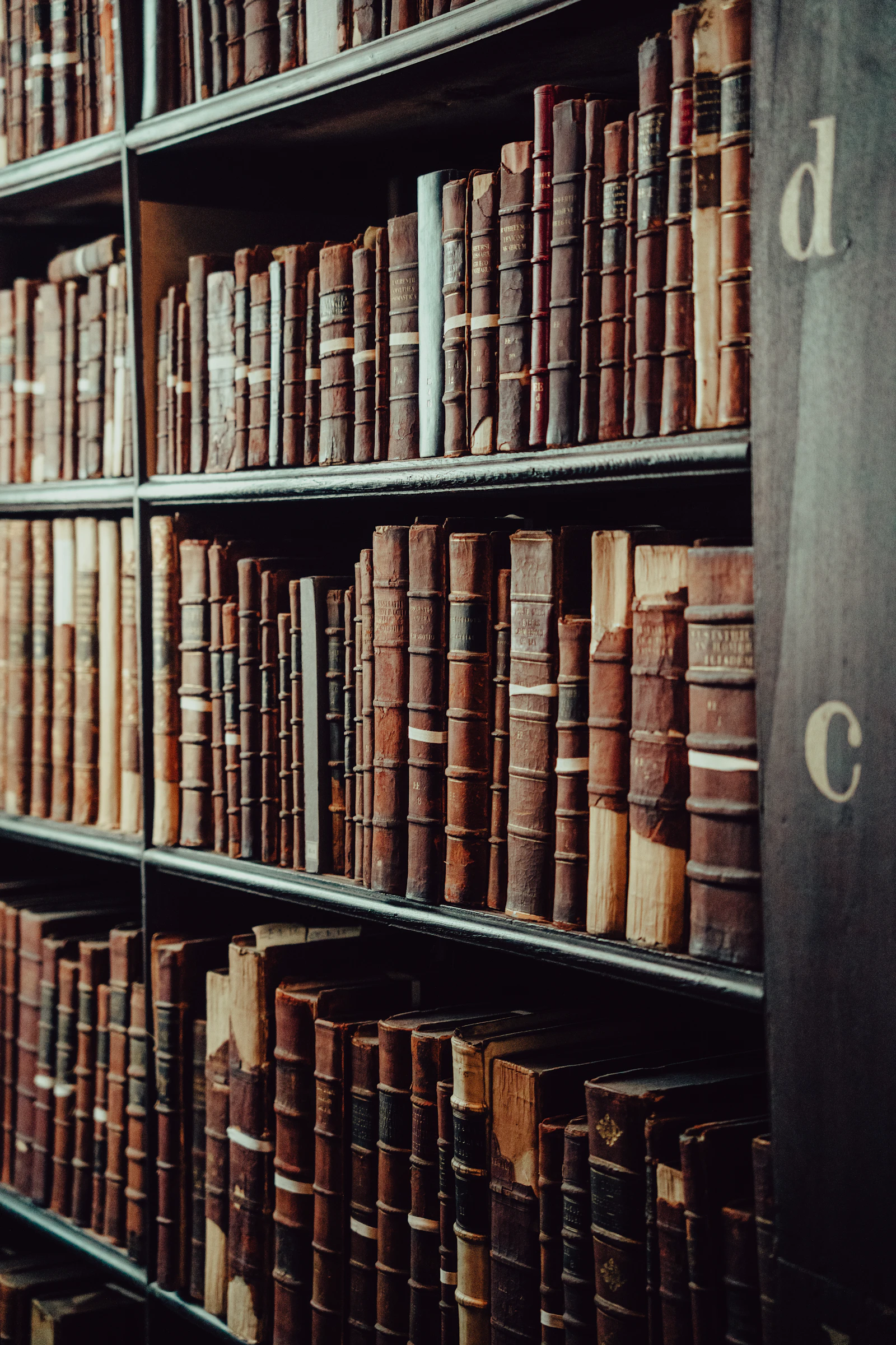 Rows of antique books filling old library shelves