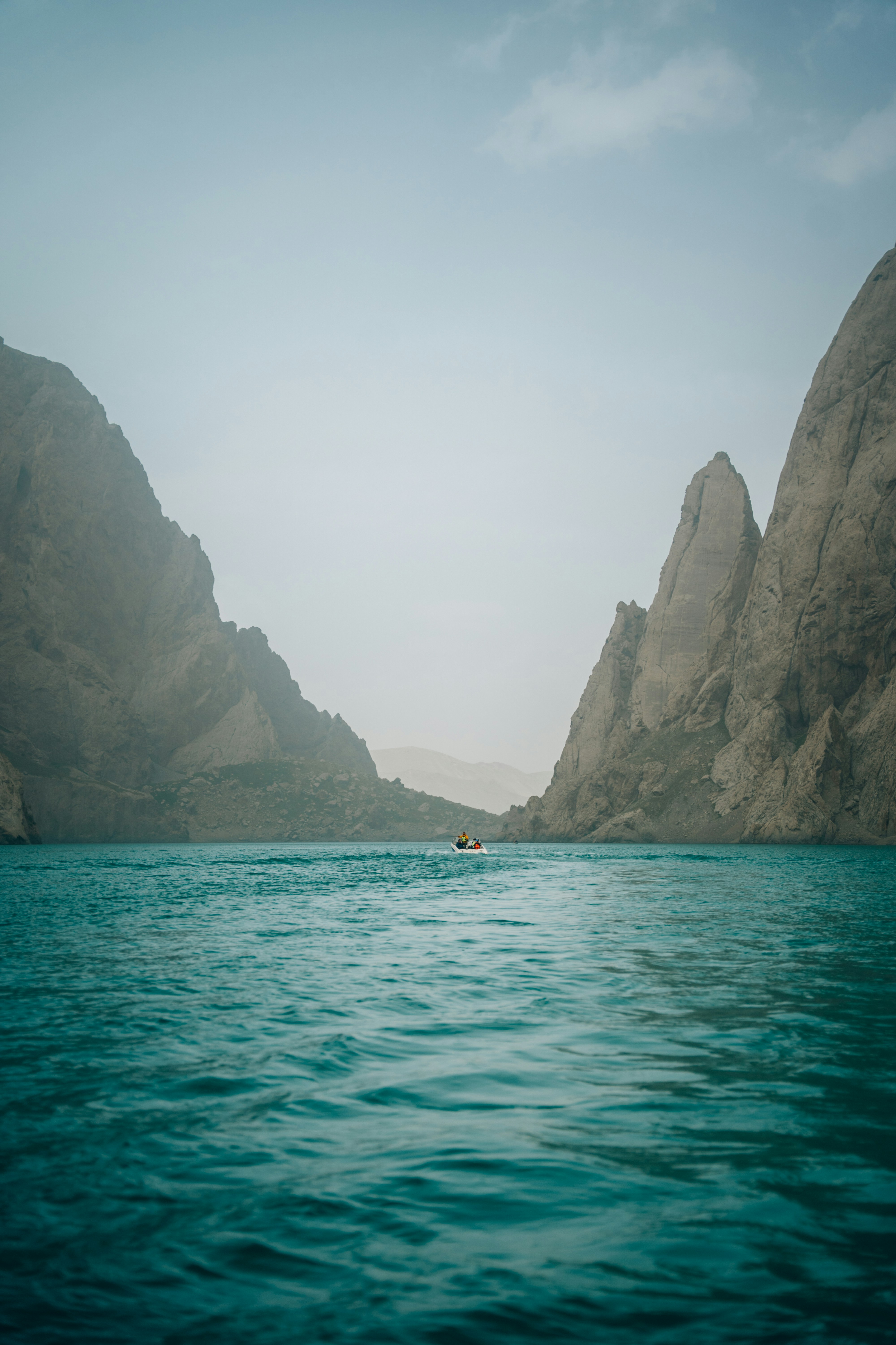 Bootsfahrt auf türkisfarbenem Wasser zwischen felsigen Klippen