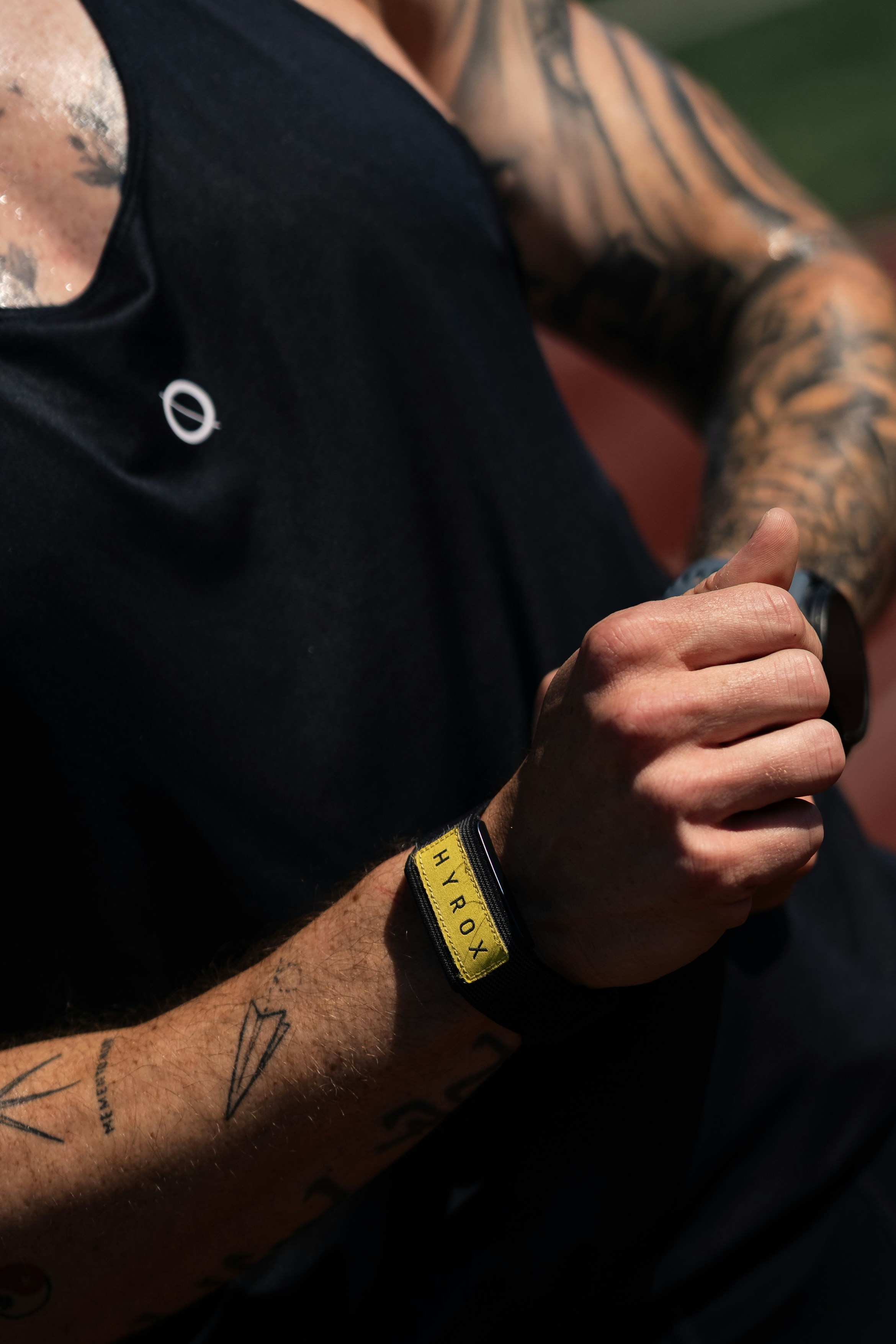 Man with tattoos checks his wristband
