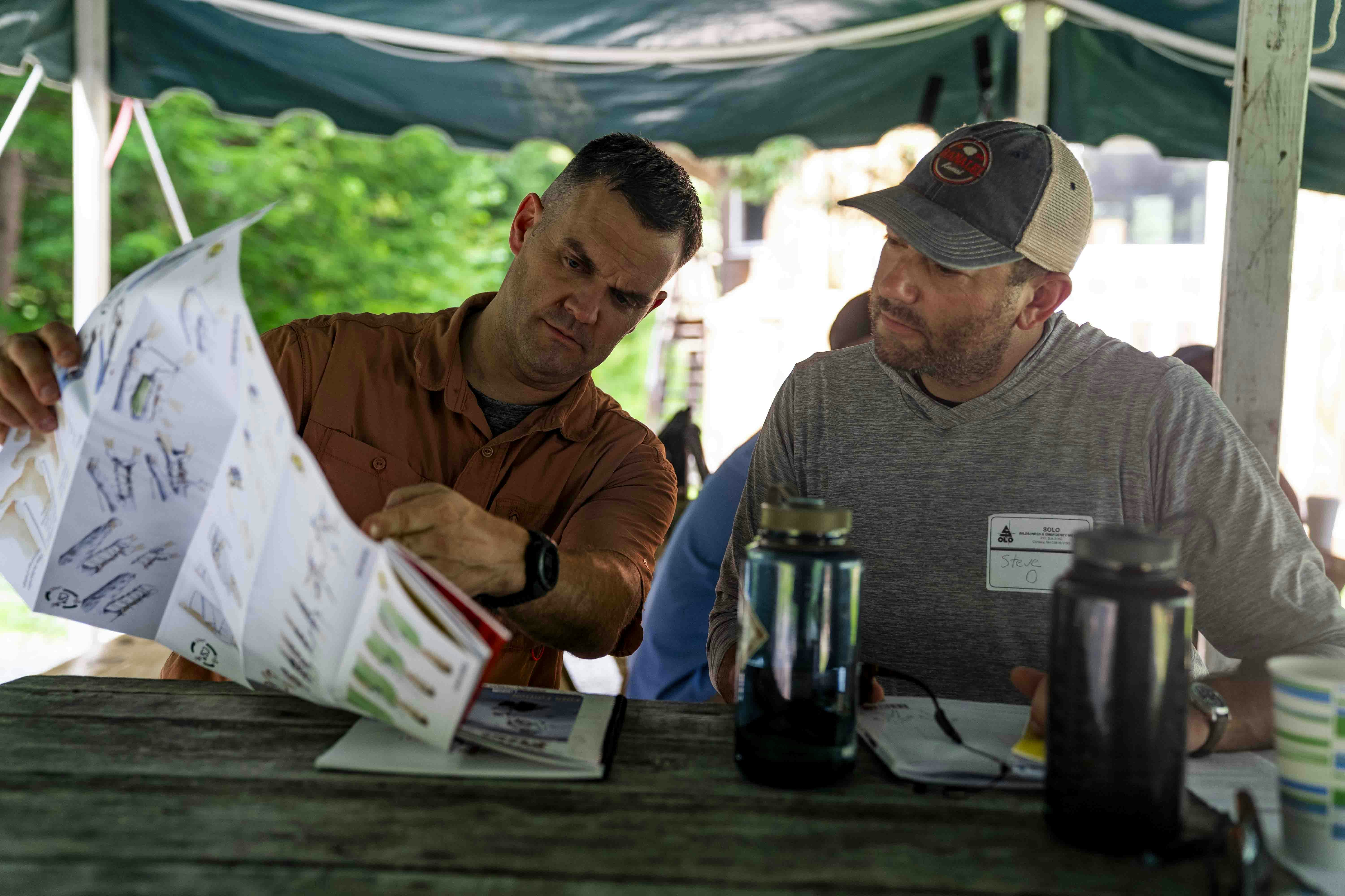 a landscape contractor discussing plans with a client on-site - landscape contracting