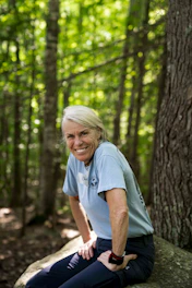 Smiling woman sitting on a rock in a forest