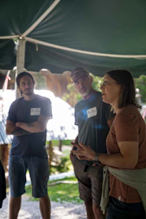 People gathered under a tent listening to a speaker