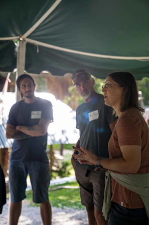 People gathered under a tent listening to a speaker