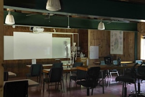 Classroom with desks, chairs, and a skeleton model.