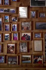 Collage of framed photographs on a wooden wall