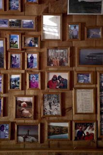 Collage of framed photographs on a wooden wall