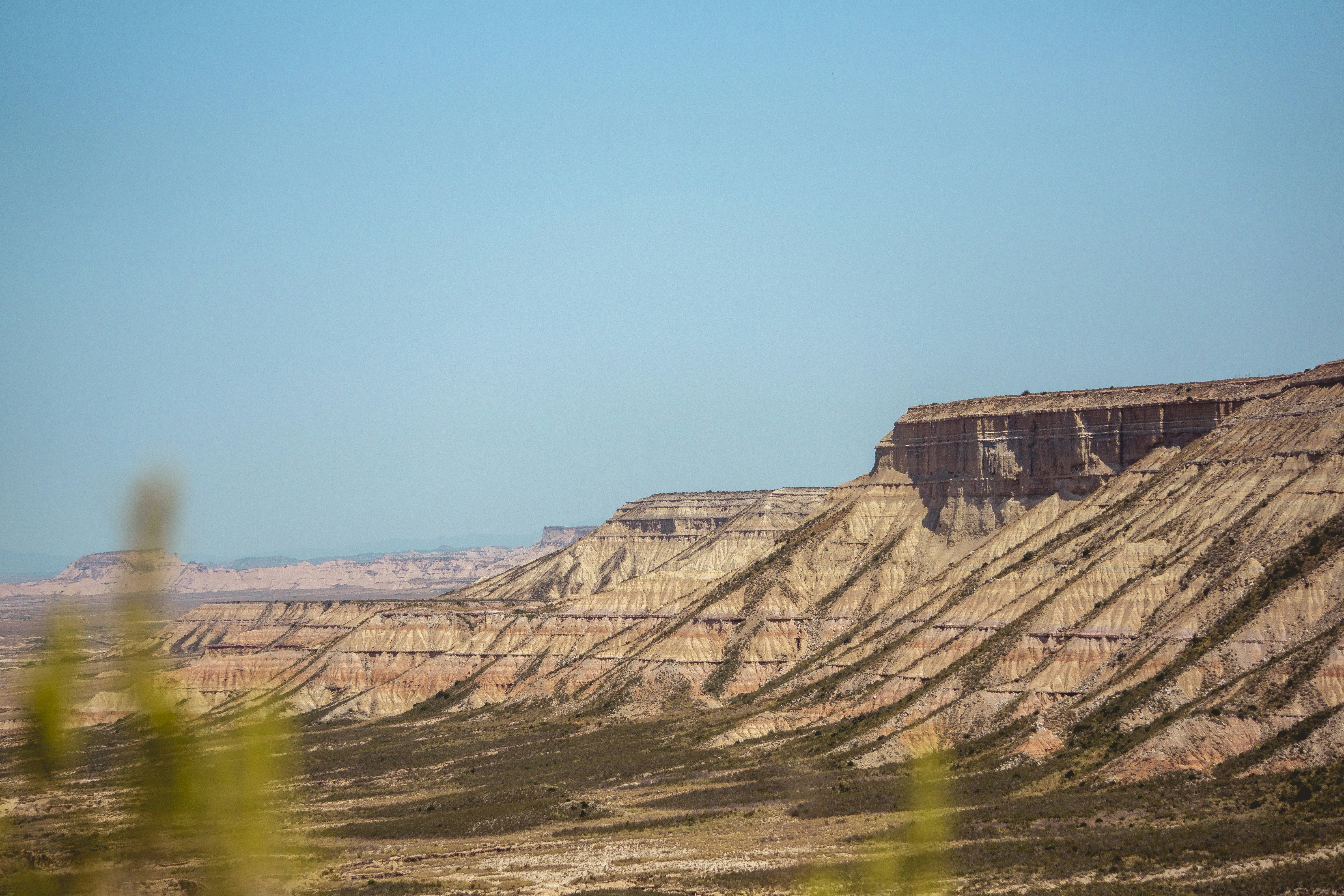 Layered desert mesas under a clear blue sky