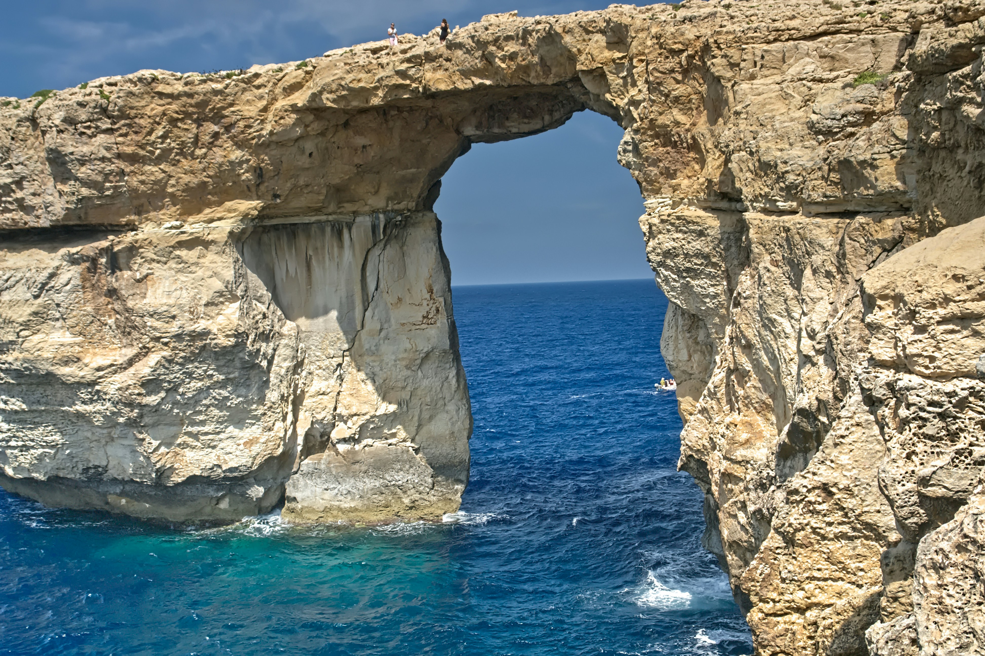 Natural rock arch over blue ocean water