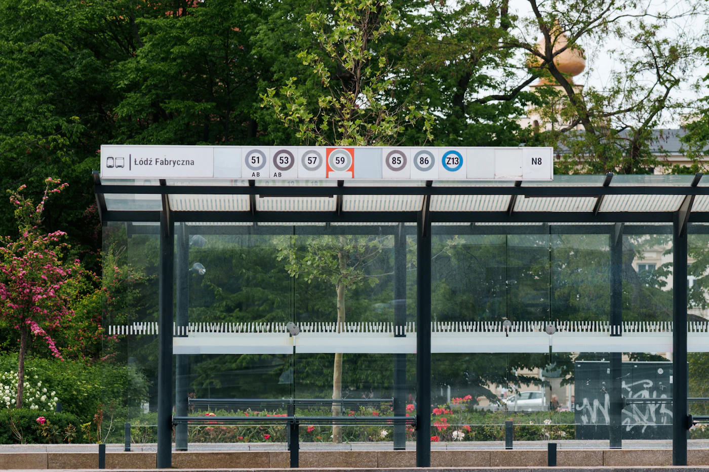 Bus stop with glass walls and signage.