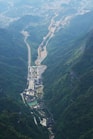 Aerial view of a winding road through a lush green mountain valley.
