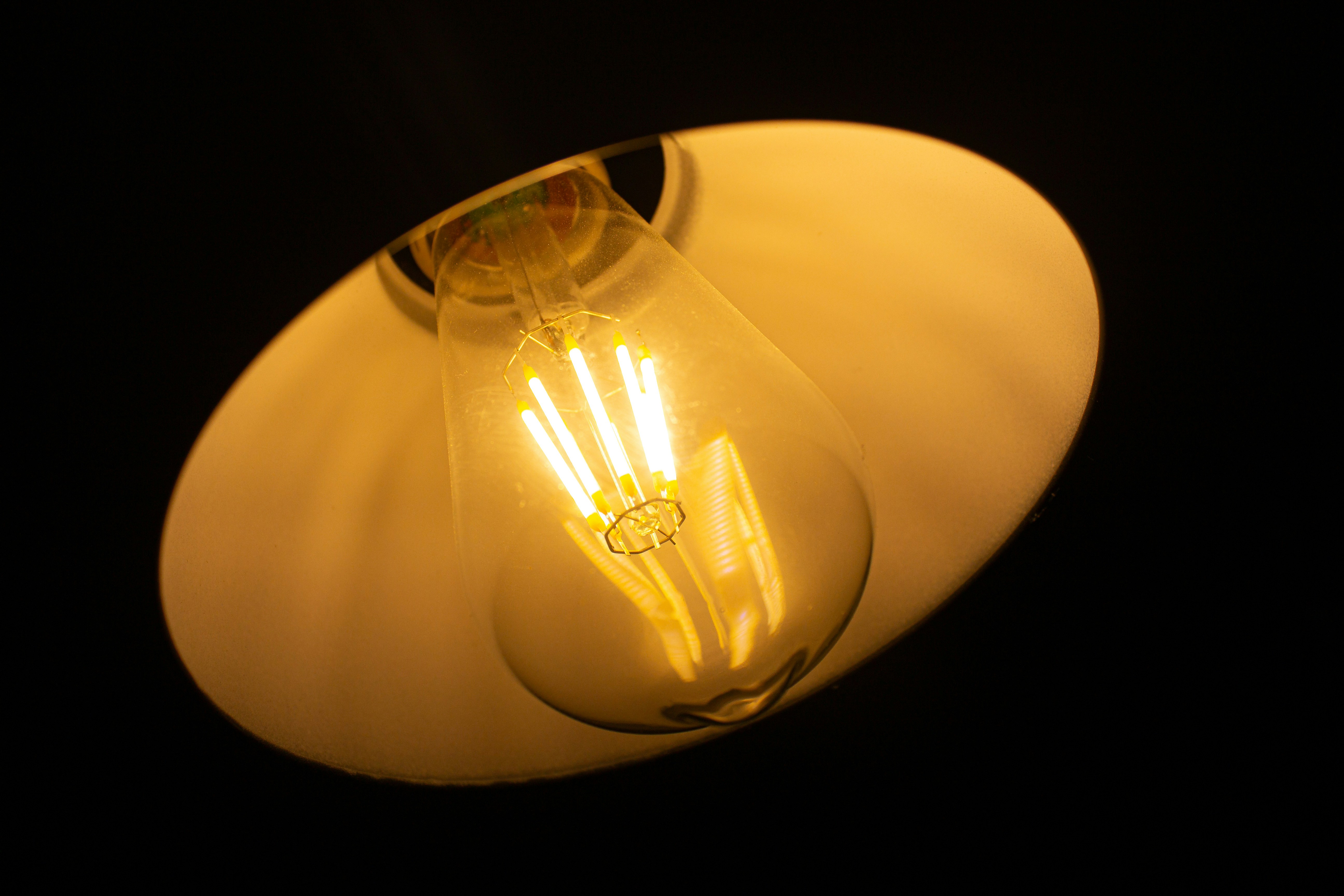 Close-up of a glowing edison light bulb in a fixture.