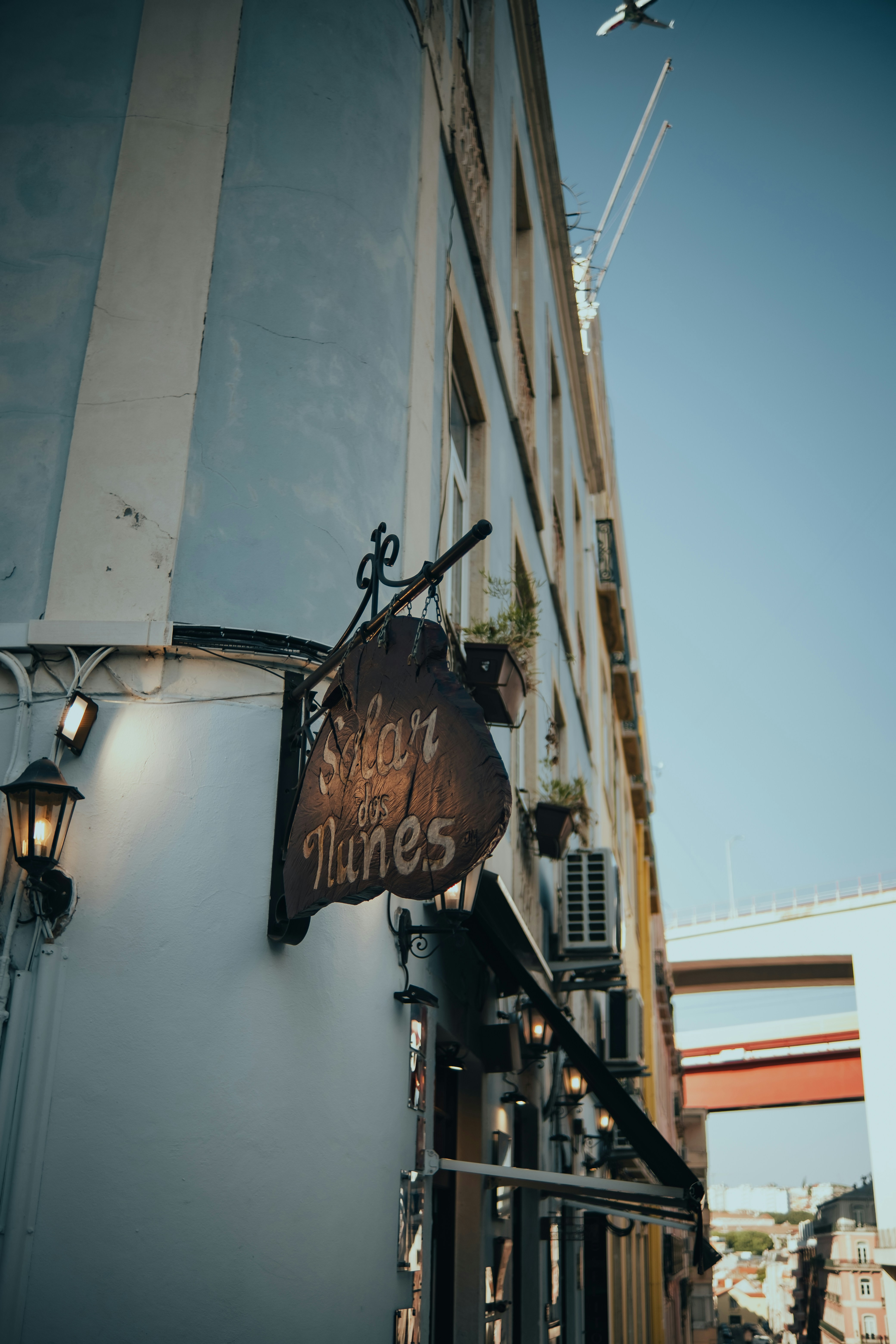 Holzschild hängt an einer Gebäudeecke