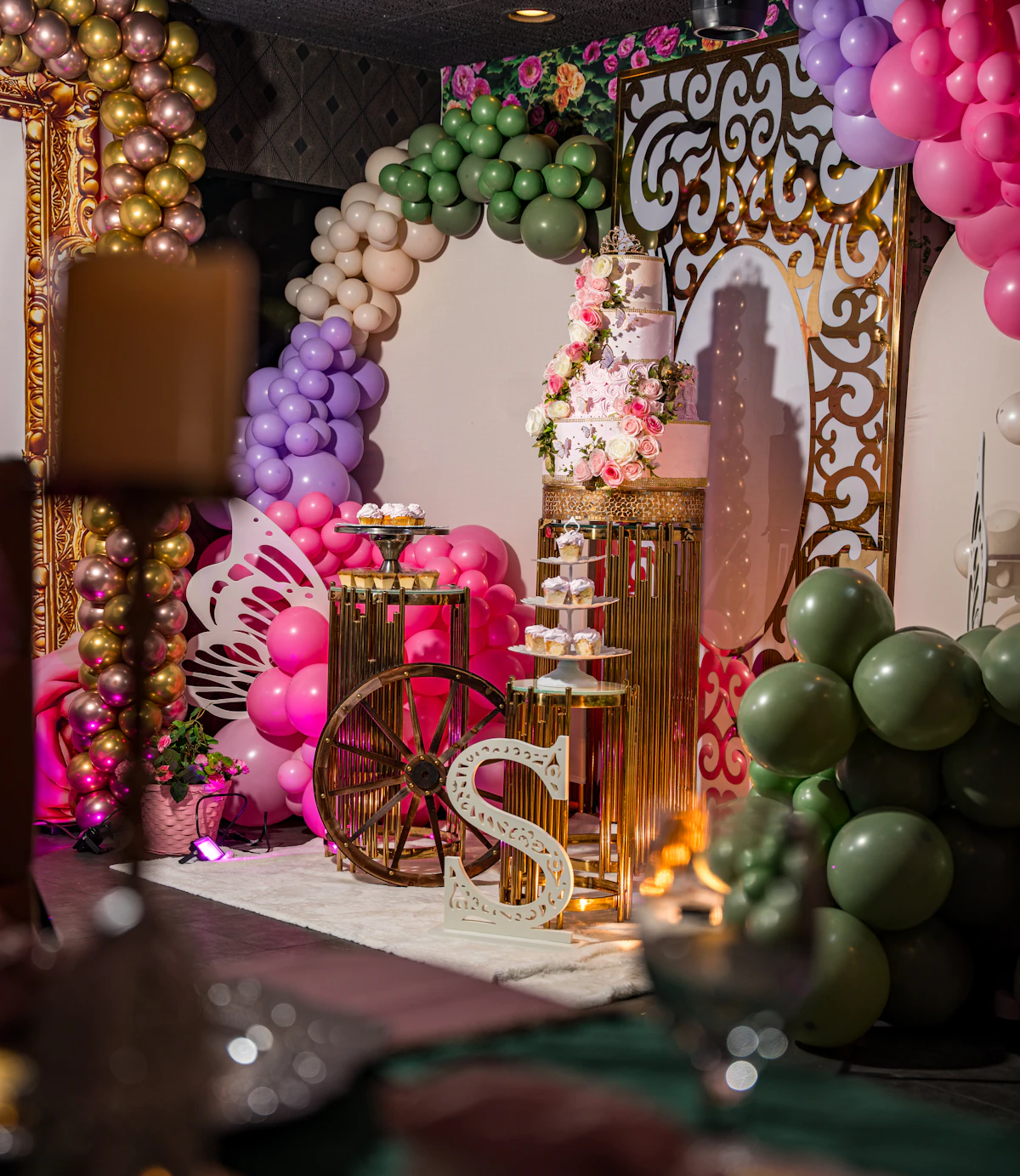 Festive dessert display with cake, balloons, and party decorations