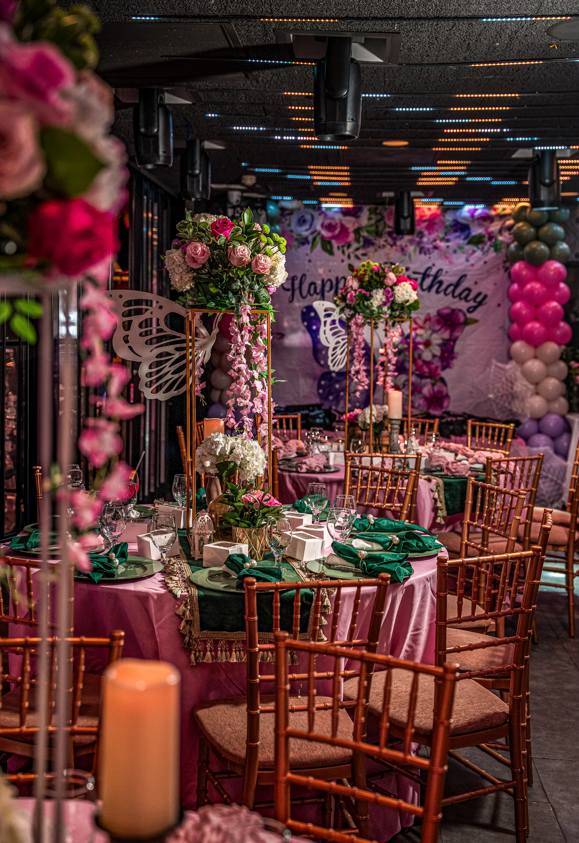 Elegant birthday party setup with floral decorations and balloons.