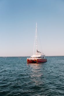 Red catamaran sailing on calm blue water