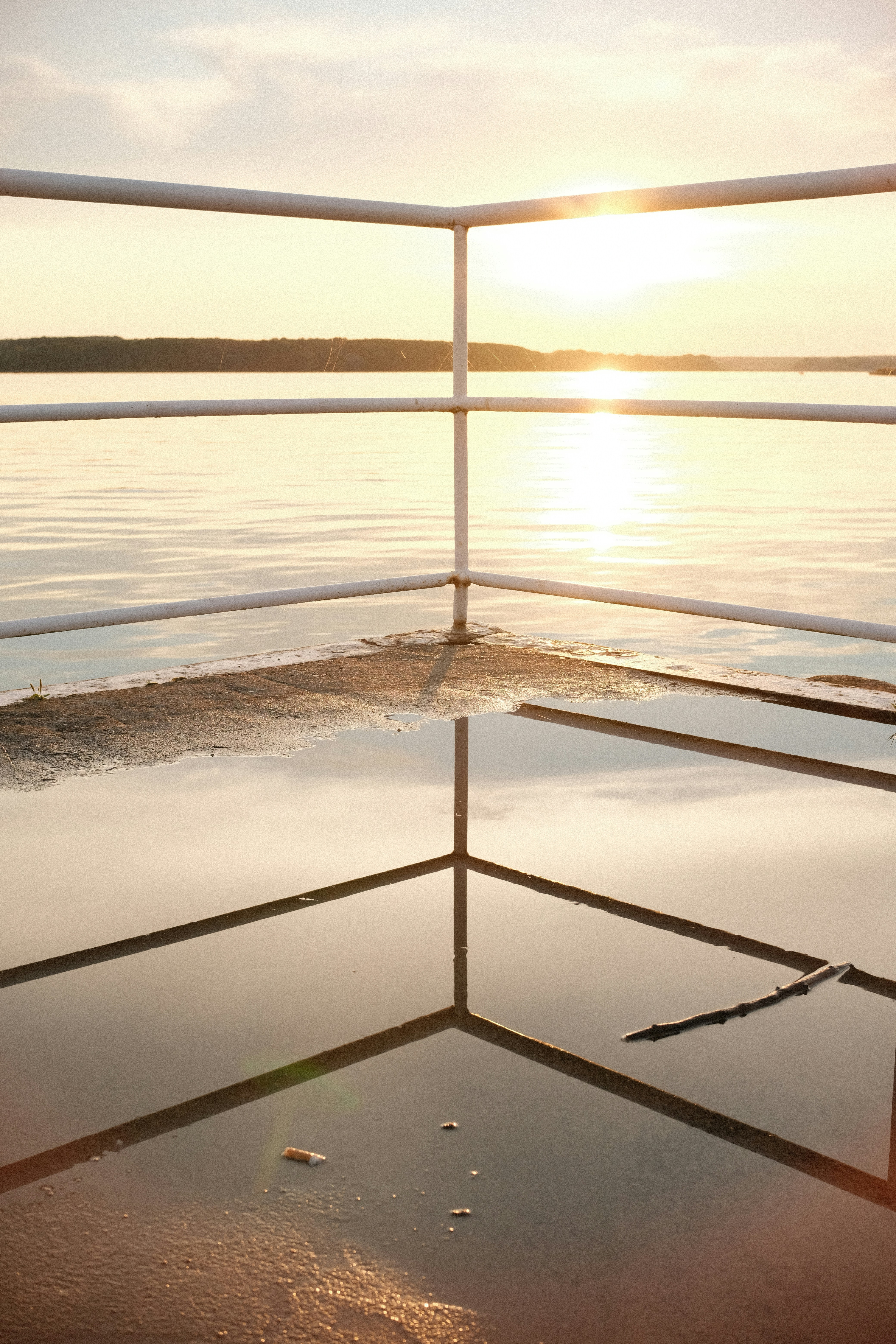 Sunset reflecting on wet pavement by the water