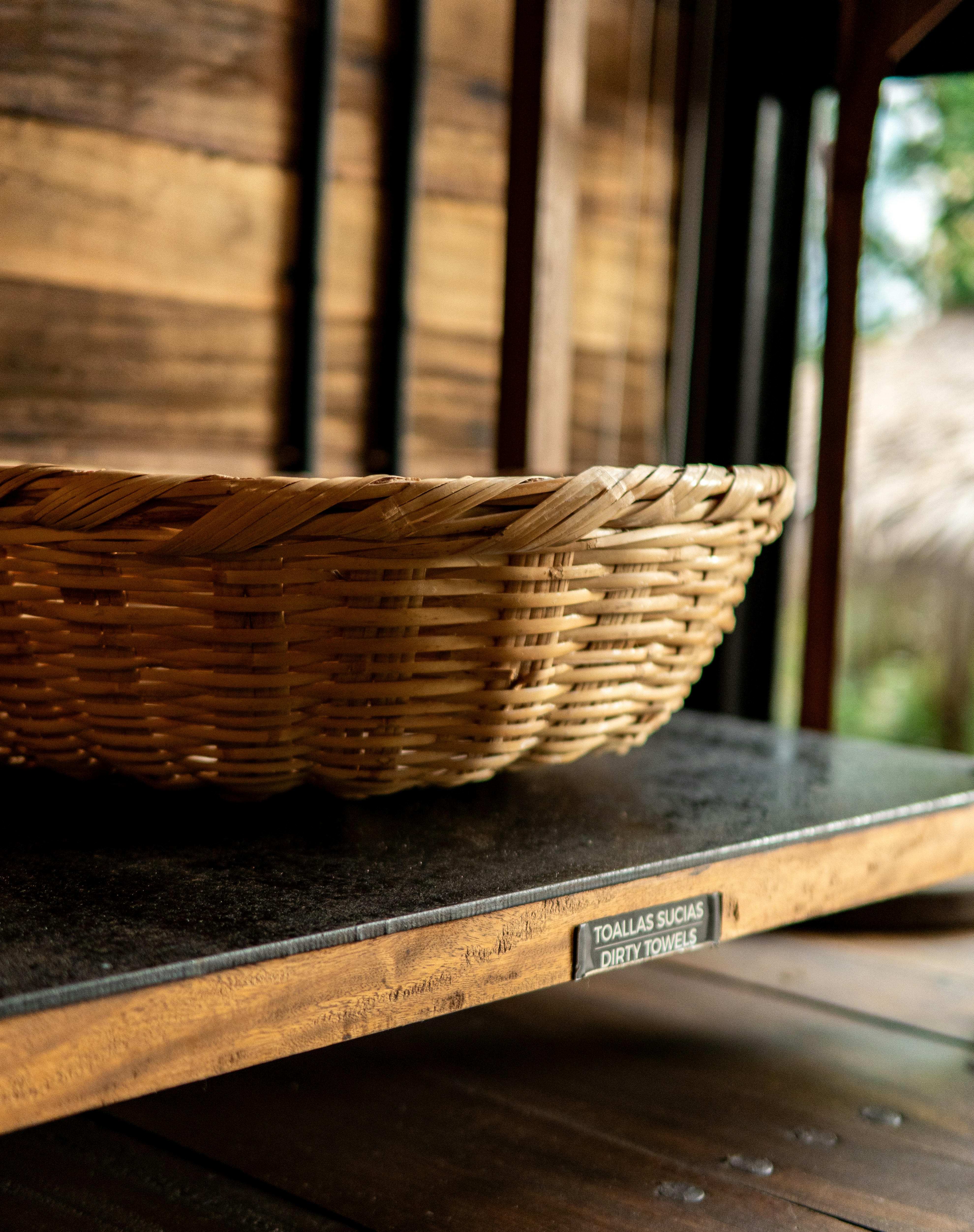 Woven basket on a wooden shelf with writing.