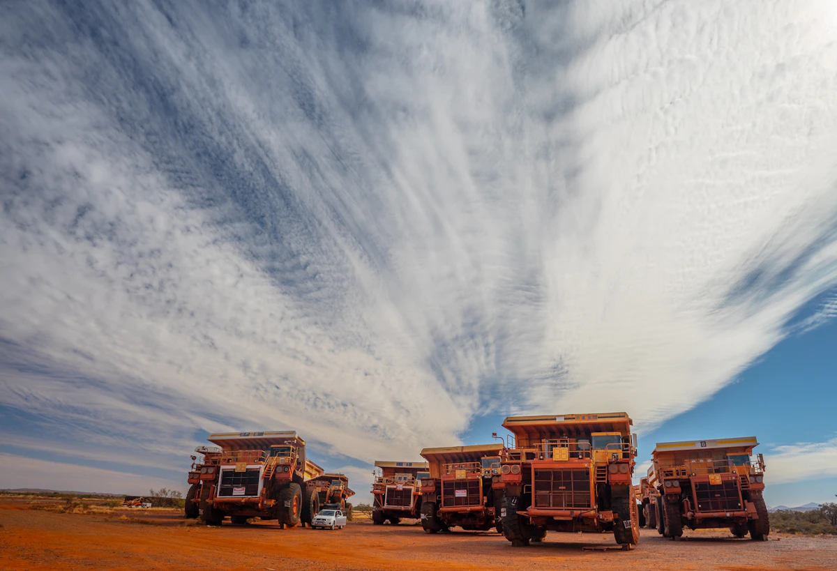 Large yellow mining haul trucks on a Western Australian site