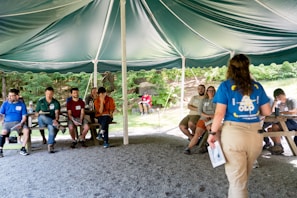 Group listening to presenter under a tent