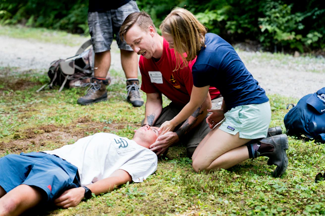 Man practicing cpr on another person outdoors