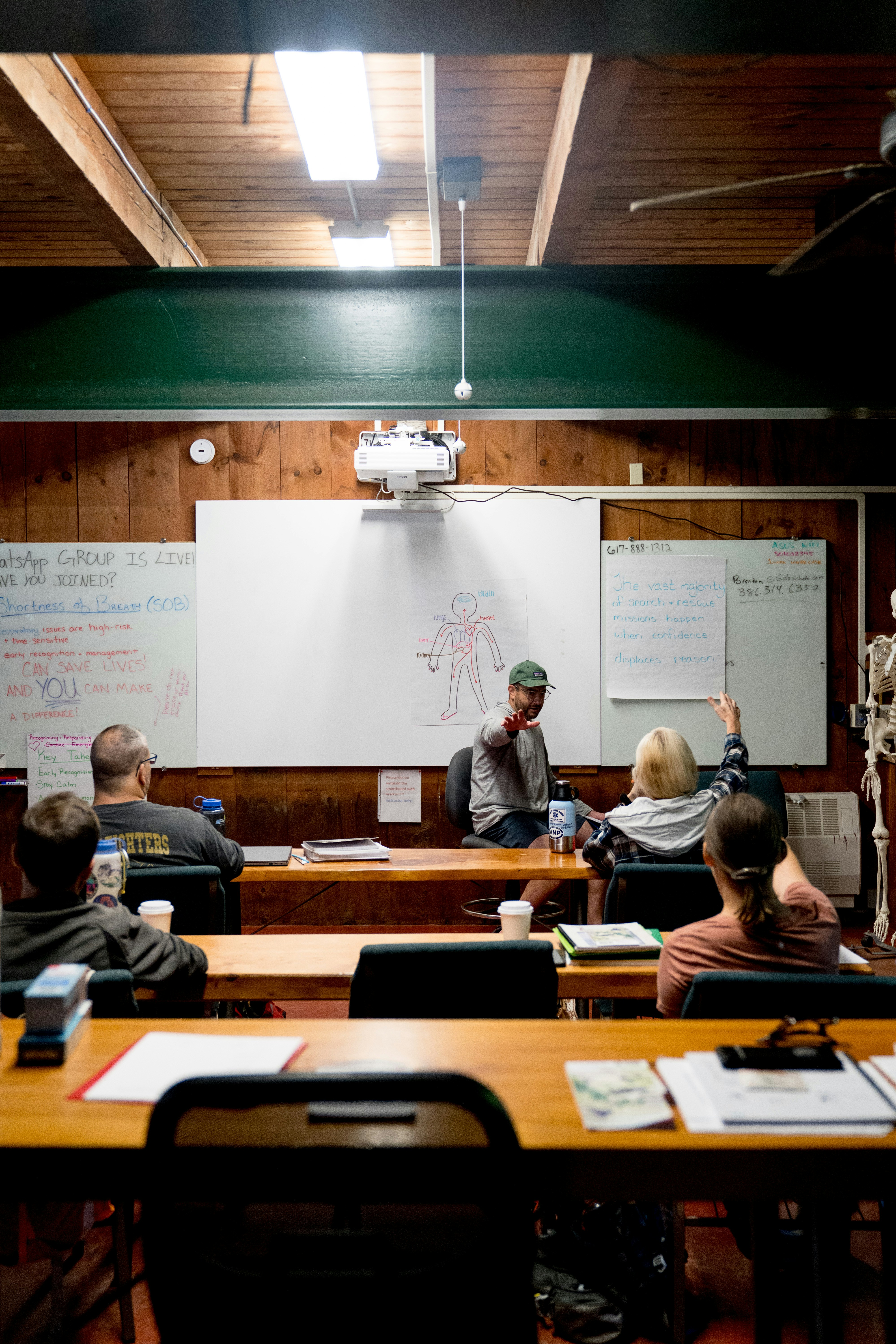 Instructor points at whiteboard during class