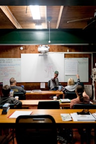Instructor points at whiteboard during class