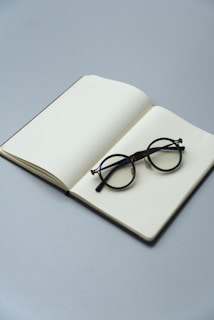Round glasses resting on an open notebook
