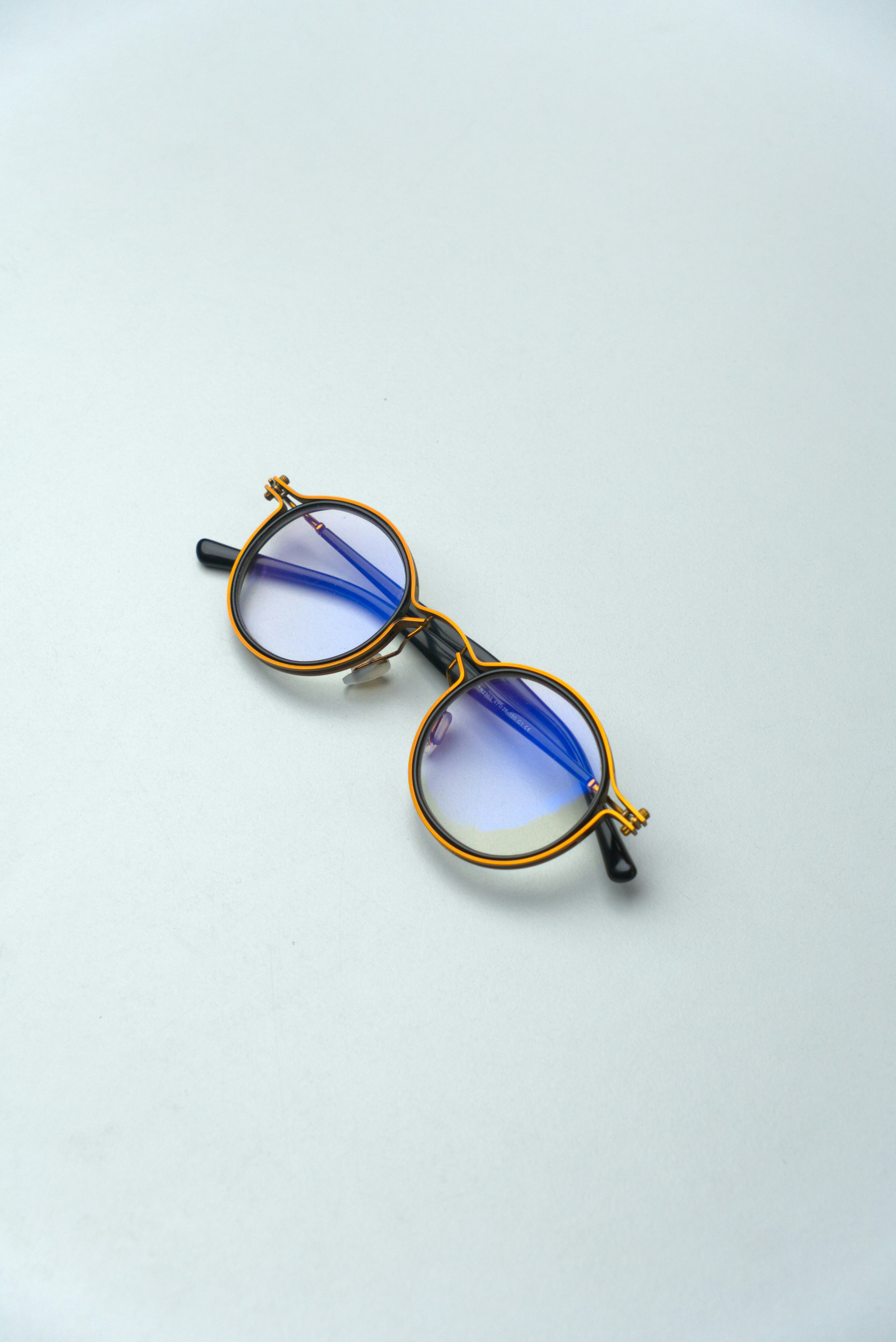 明るい背景にゴールドのフレームが付いた丸い眼鏡