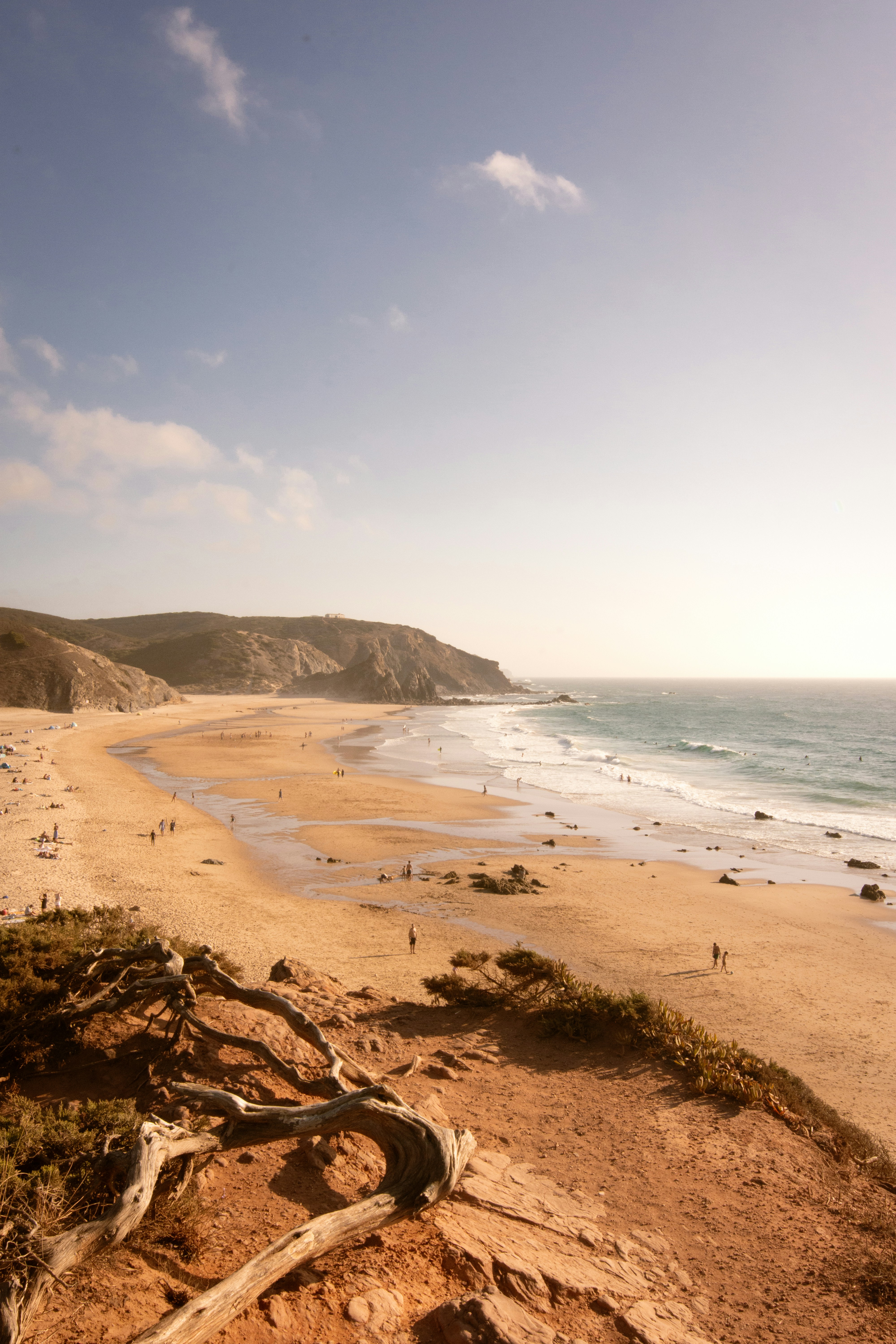 Sandy beach with gentle waves and distant cliffs