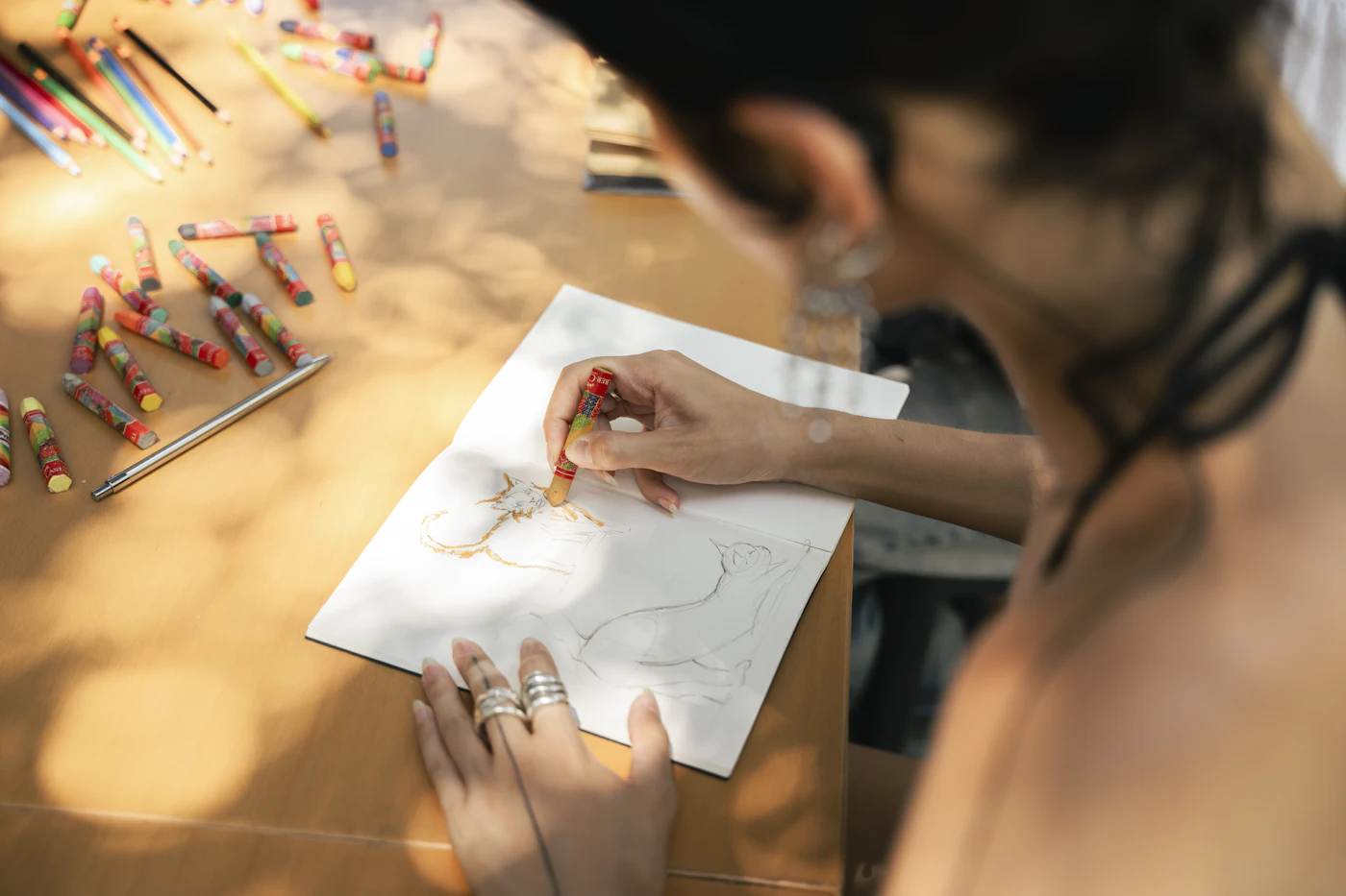 Drawing with crayons at a table during a mindfulness art session