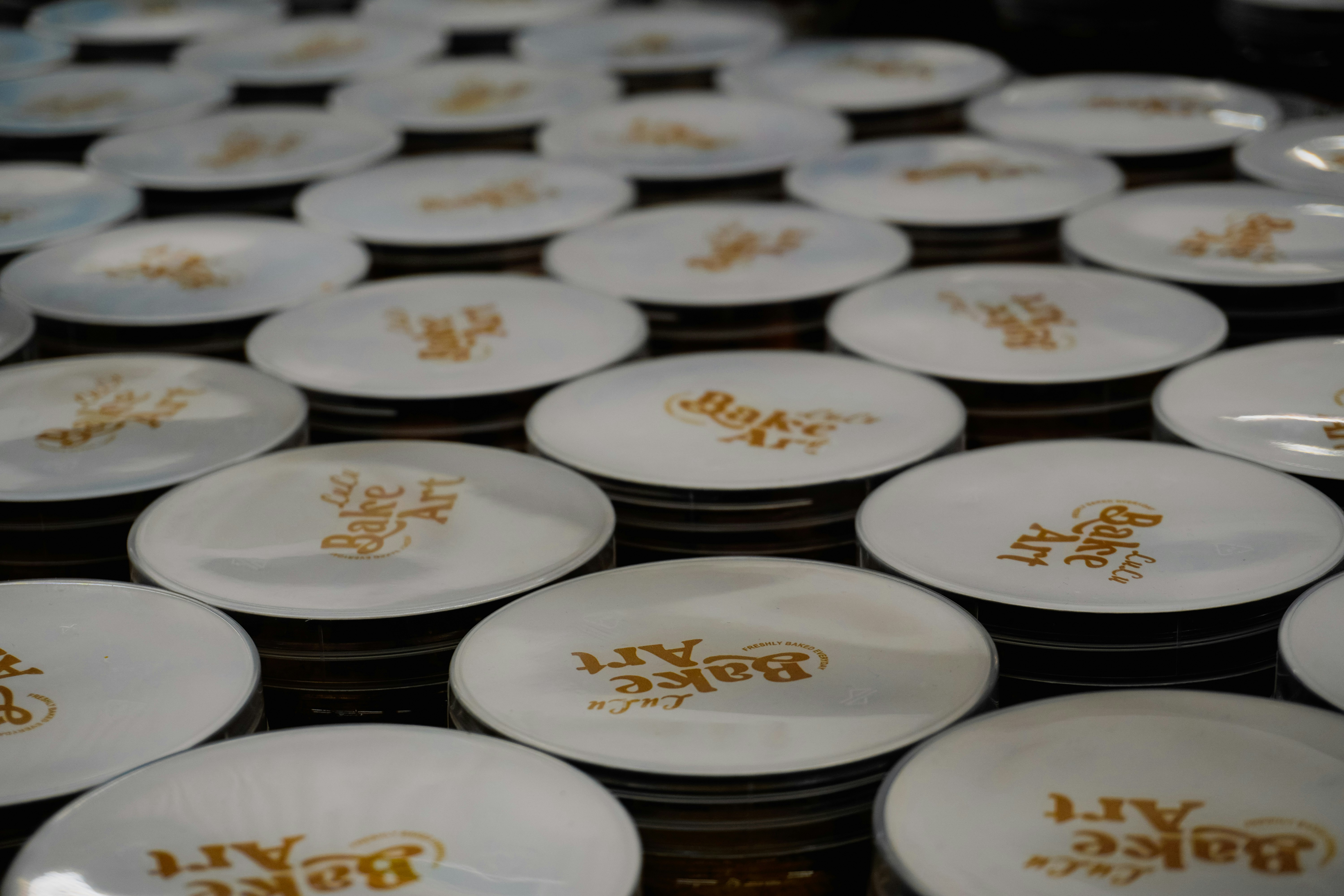 Filas de platos blancos con letras doradas