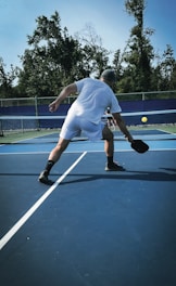 Man playing pickleball on a blue court