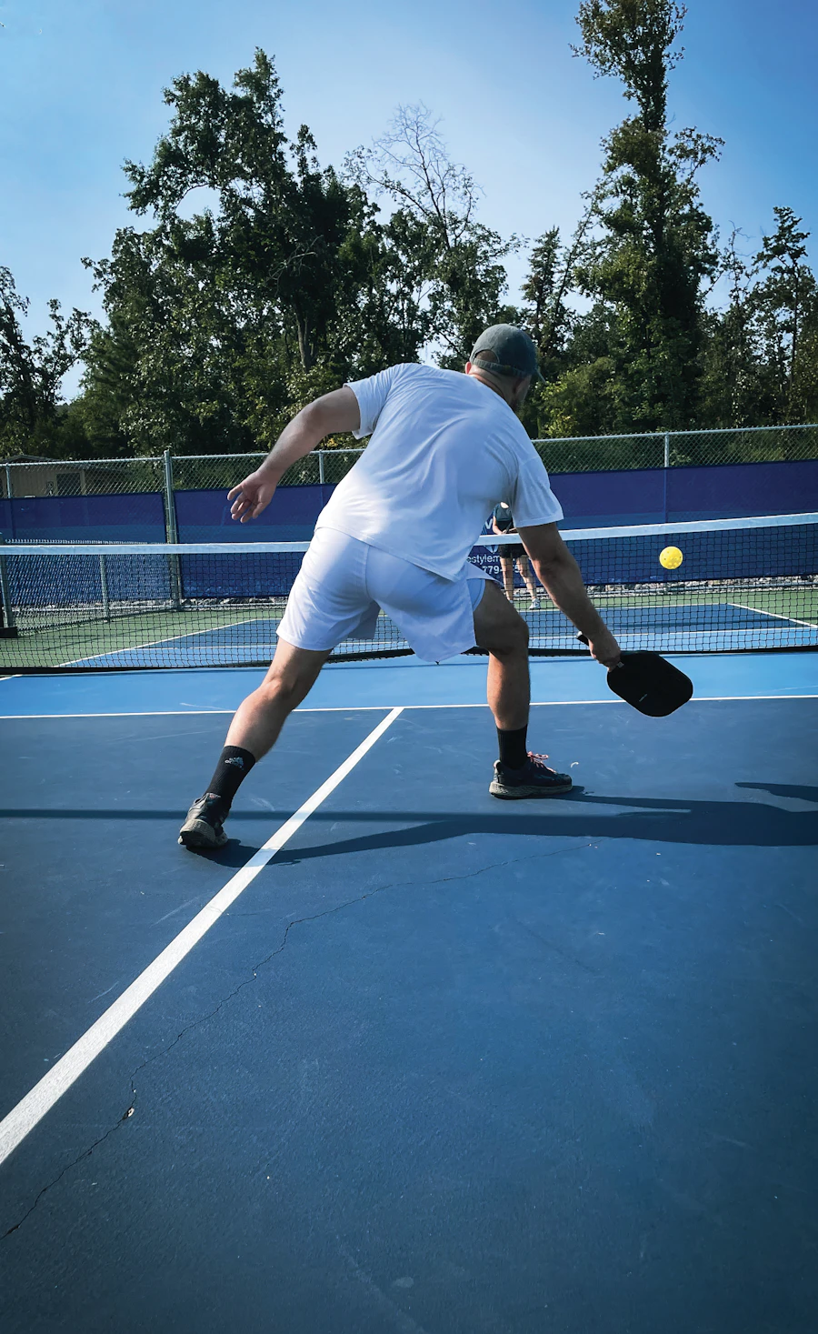 Mid-rally on the blue court, paddle low for the dink