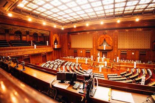 Grand legislative chamber with tiered seating and ornate woodwork.