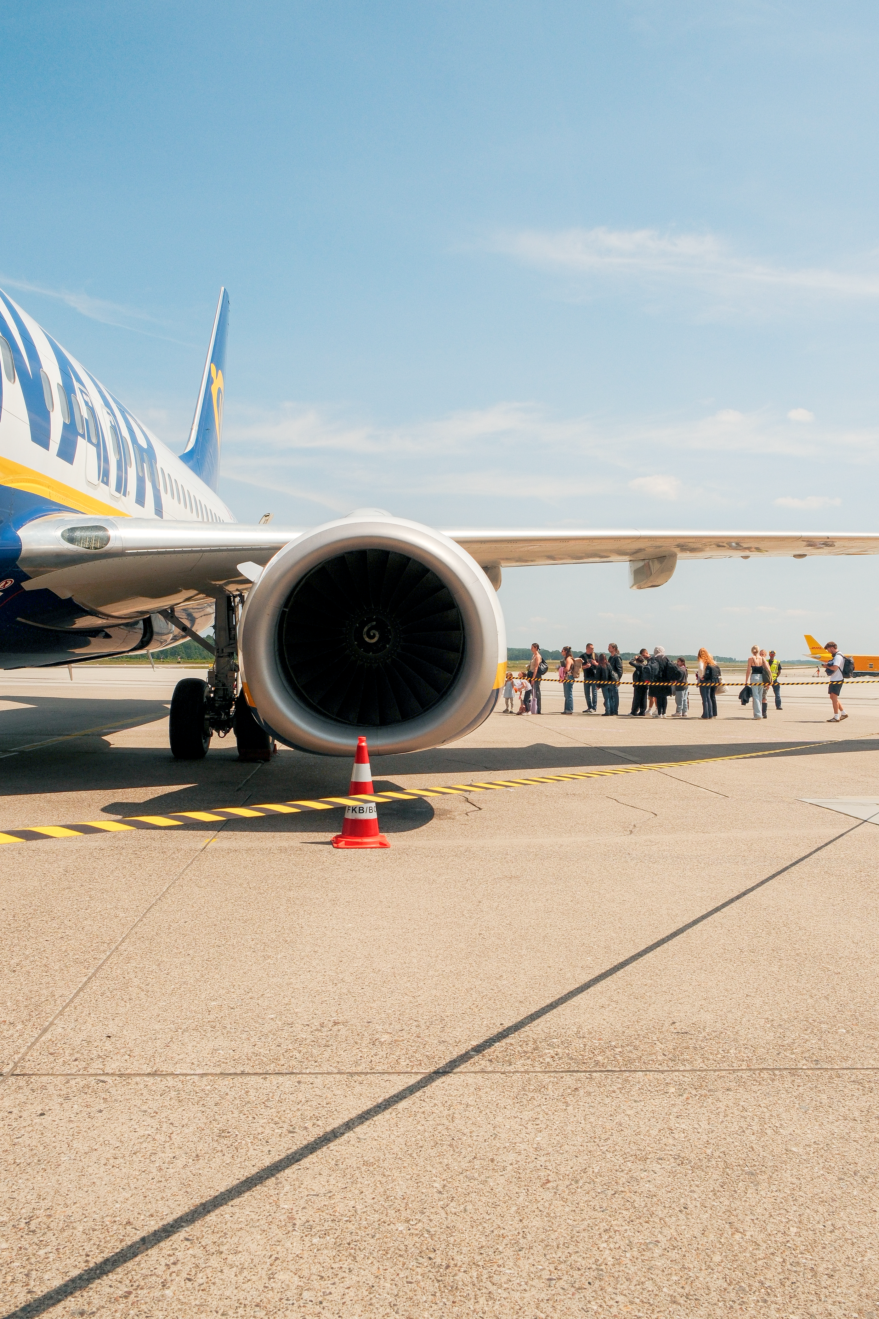 Airplane engine and passengers boarding on tarmac