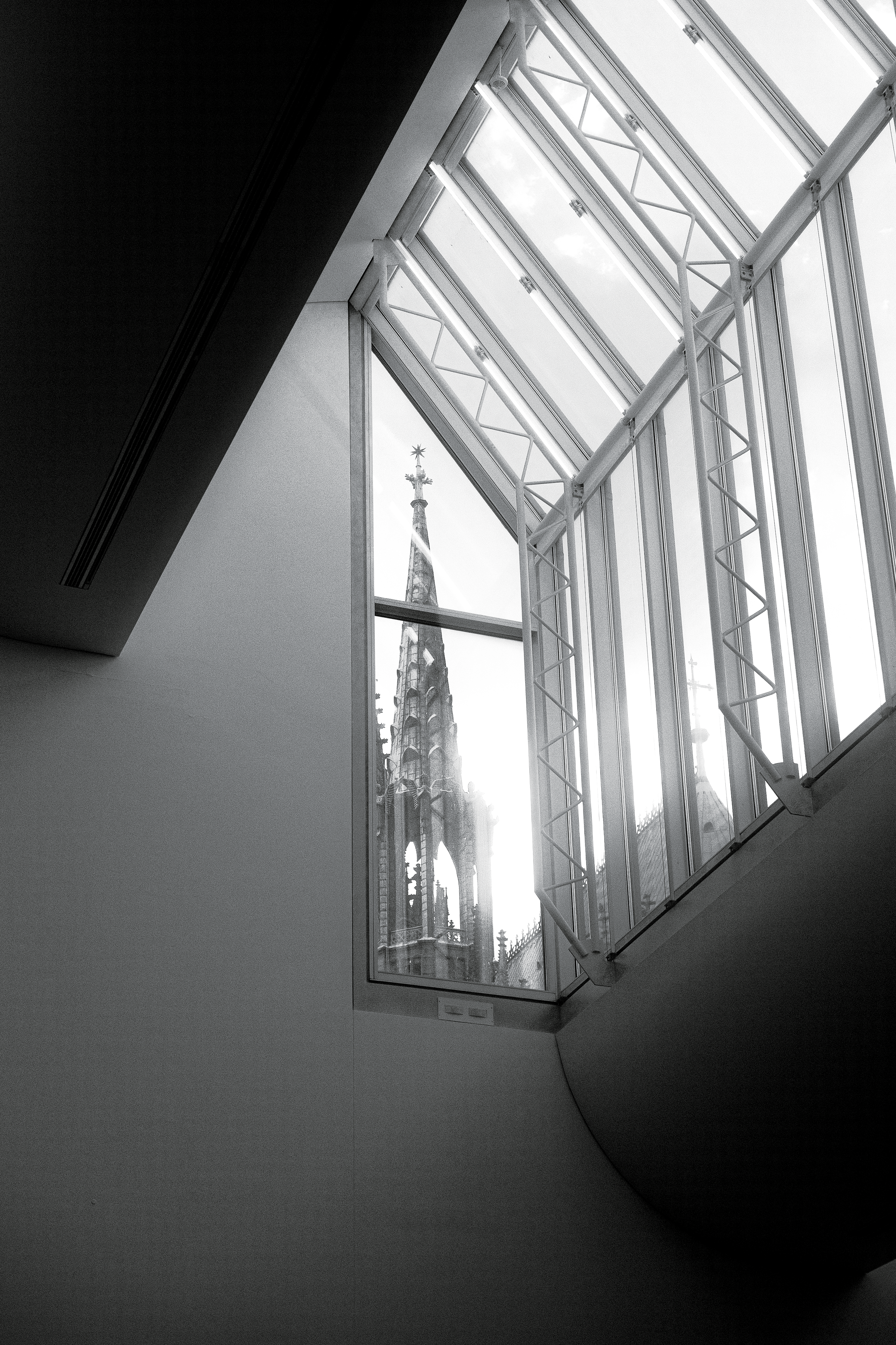 Gothic cathedral spire seen through modern window
