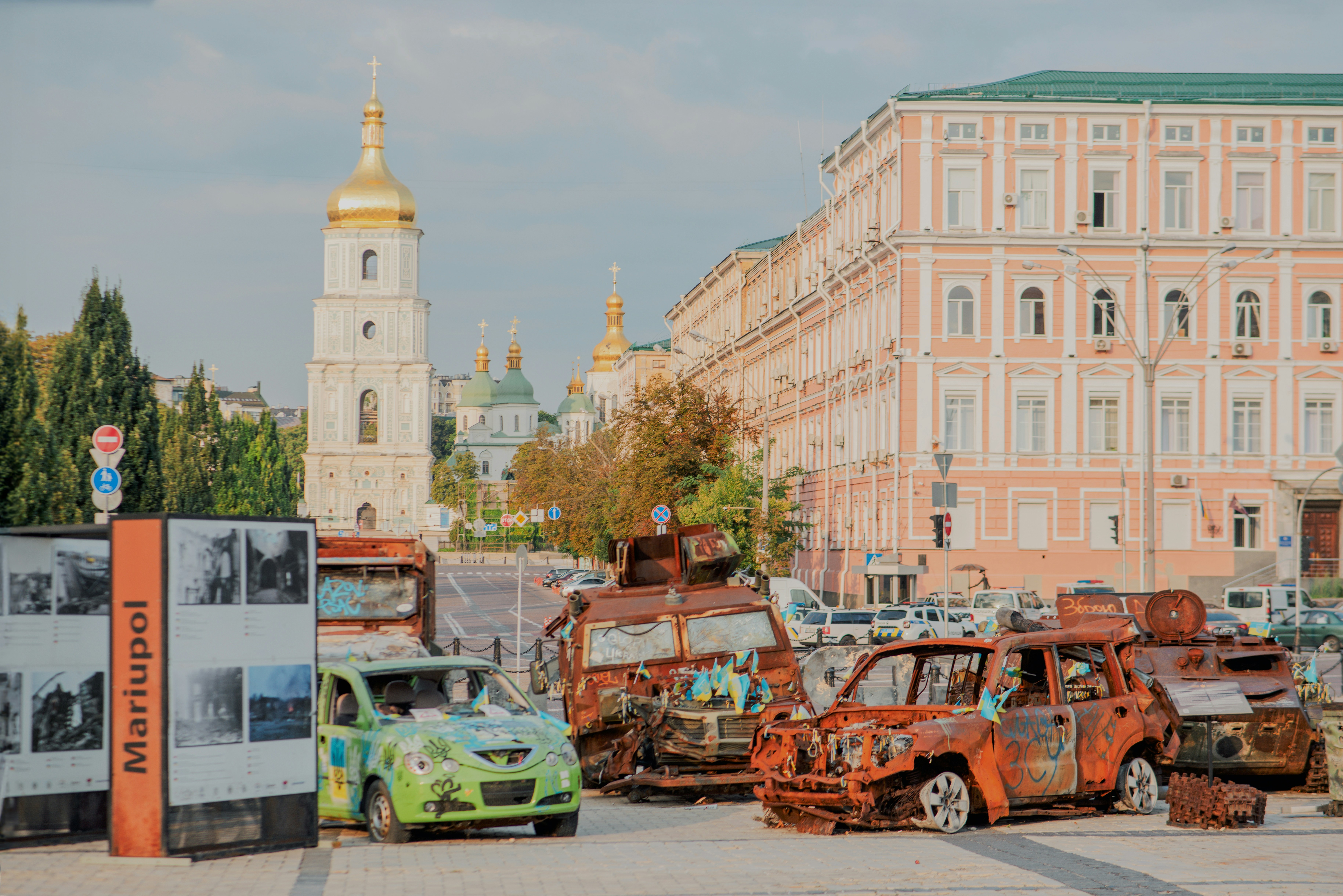 Destroyed vehicles displayed near historic buildings