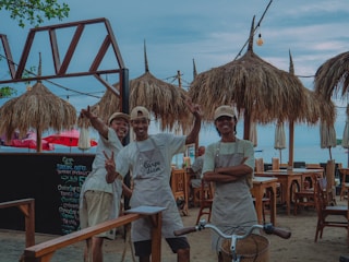 Three smiling people posing at an outdoor restaurant.