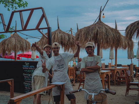 Three smiling people posing at an outdoor restaurant.