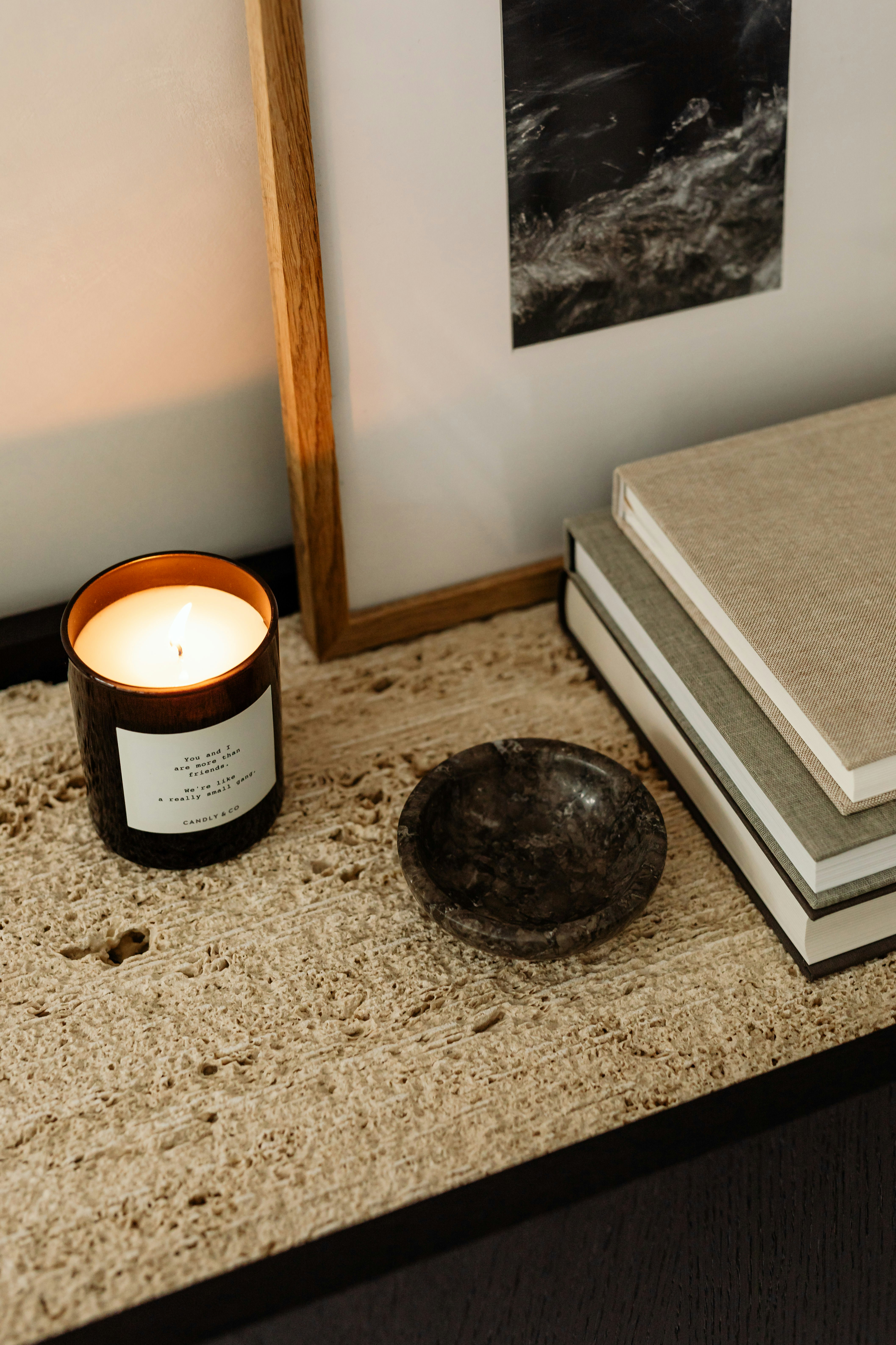 Lit candle and small dish on textured surface