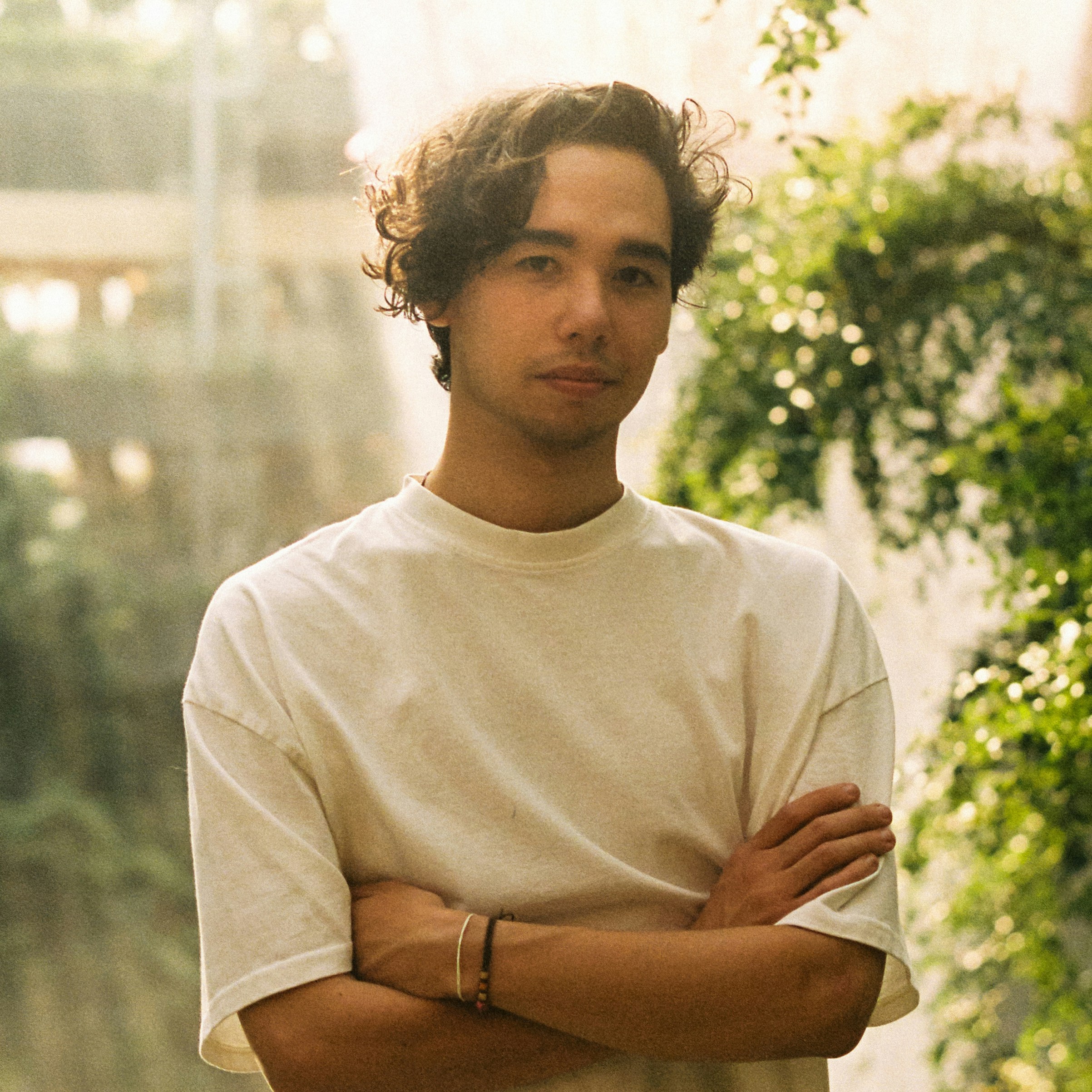 초록 앞에서 팔짱을 끼고 있는 청년