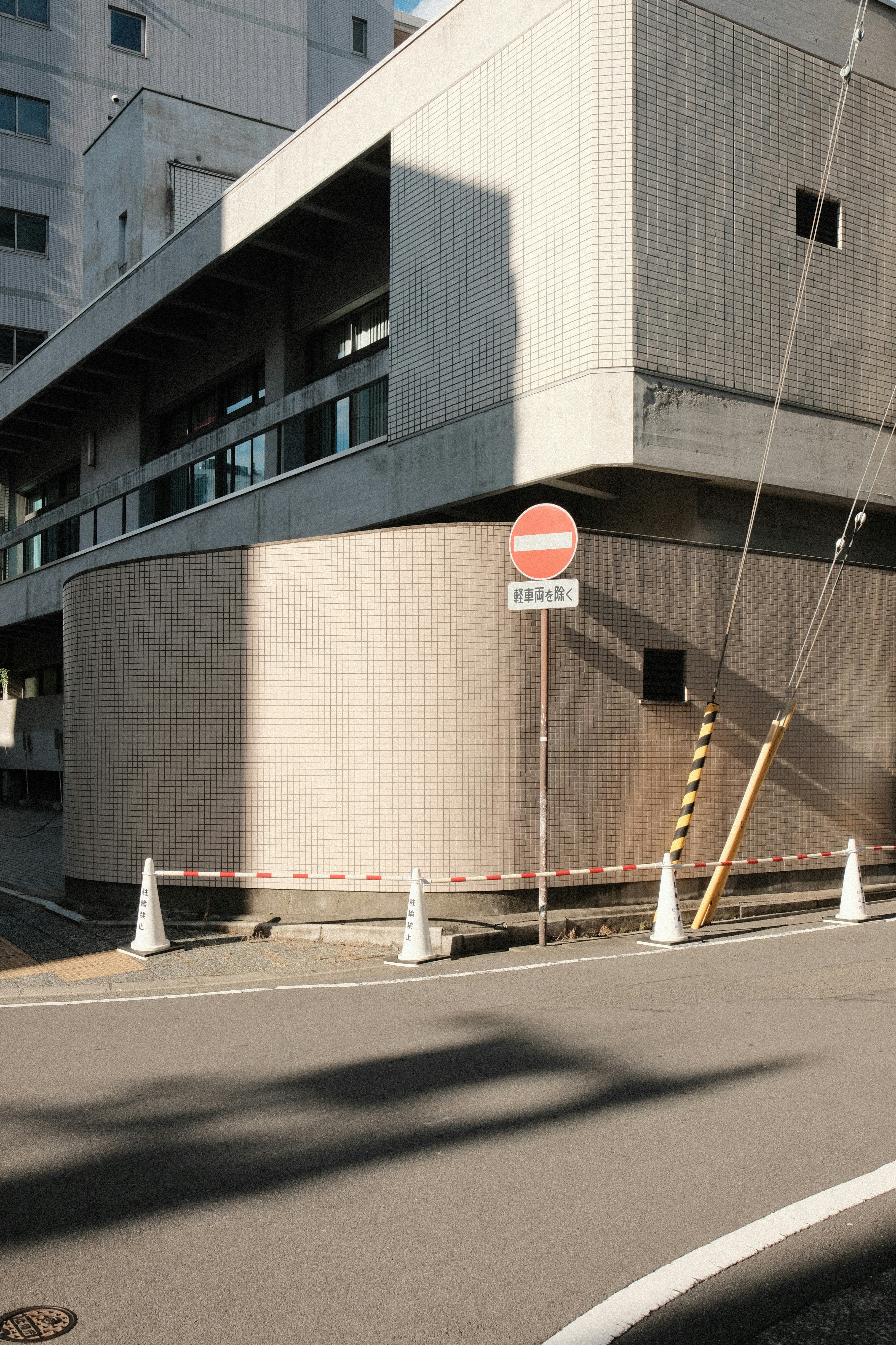 Modern building with a no entry sign and cones