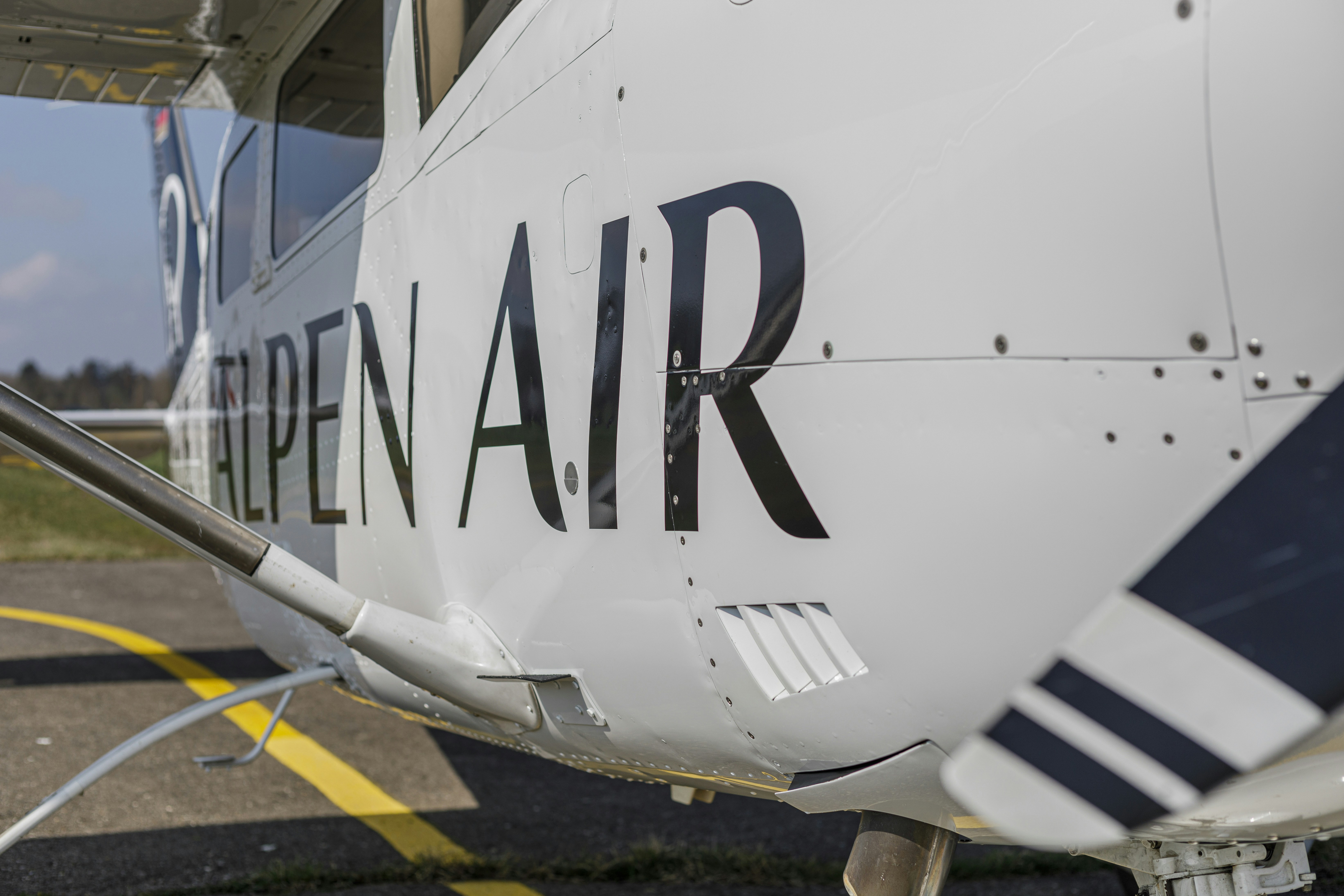 Close-up of a white airplane with "alpen air" text