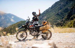 Person with motorcycle on mountain road