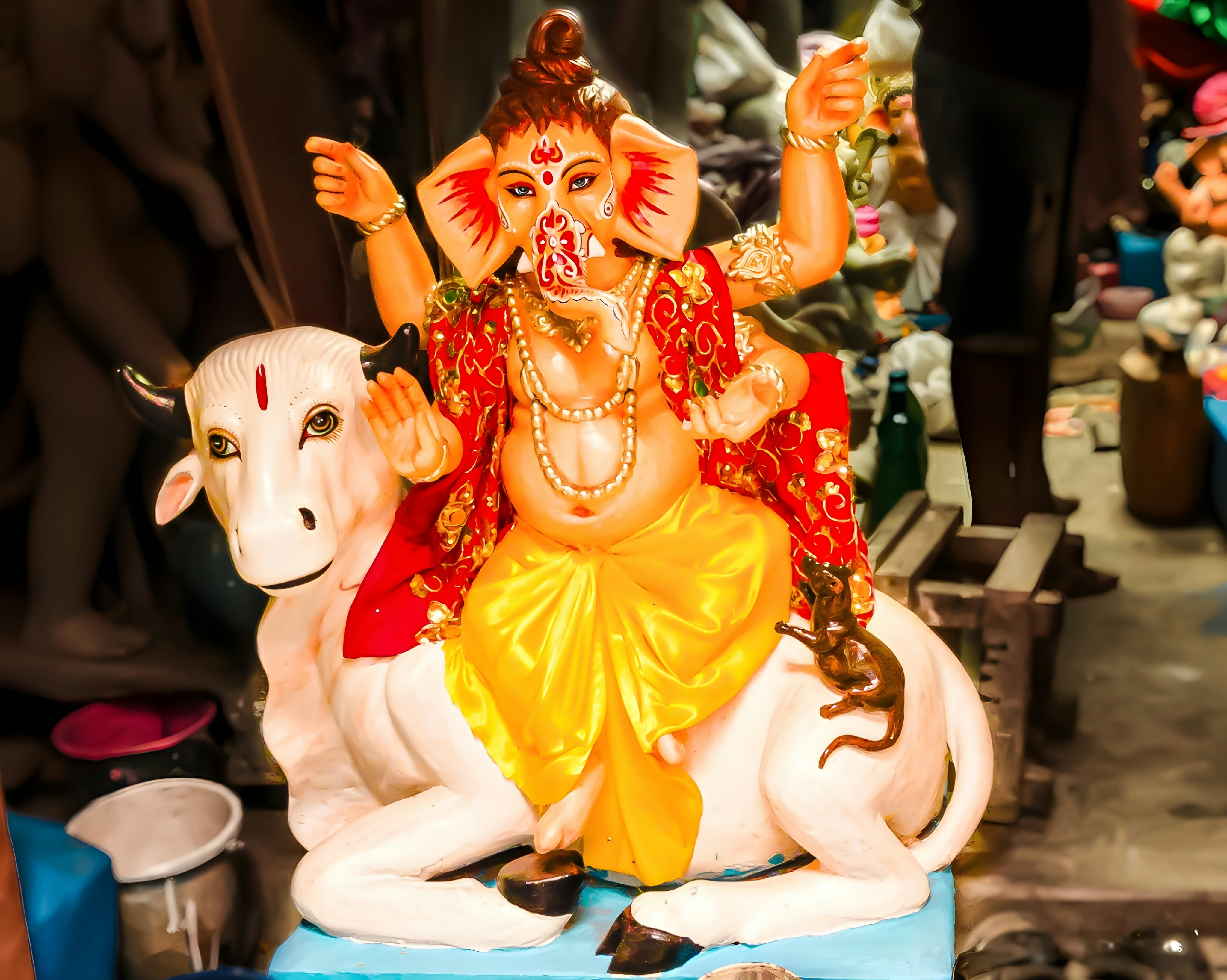 Ganesha rides a white cow with red and yellow attire