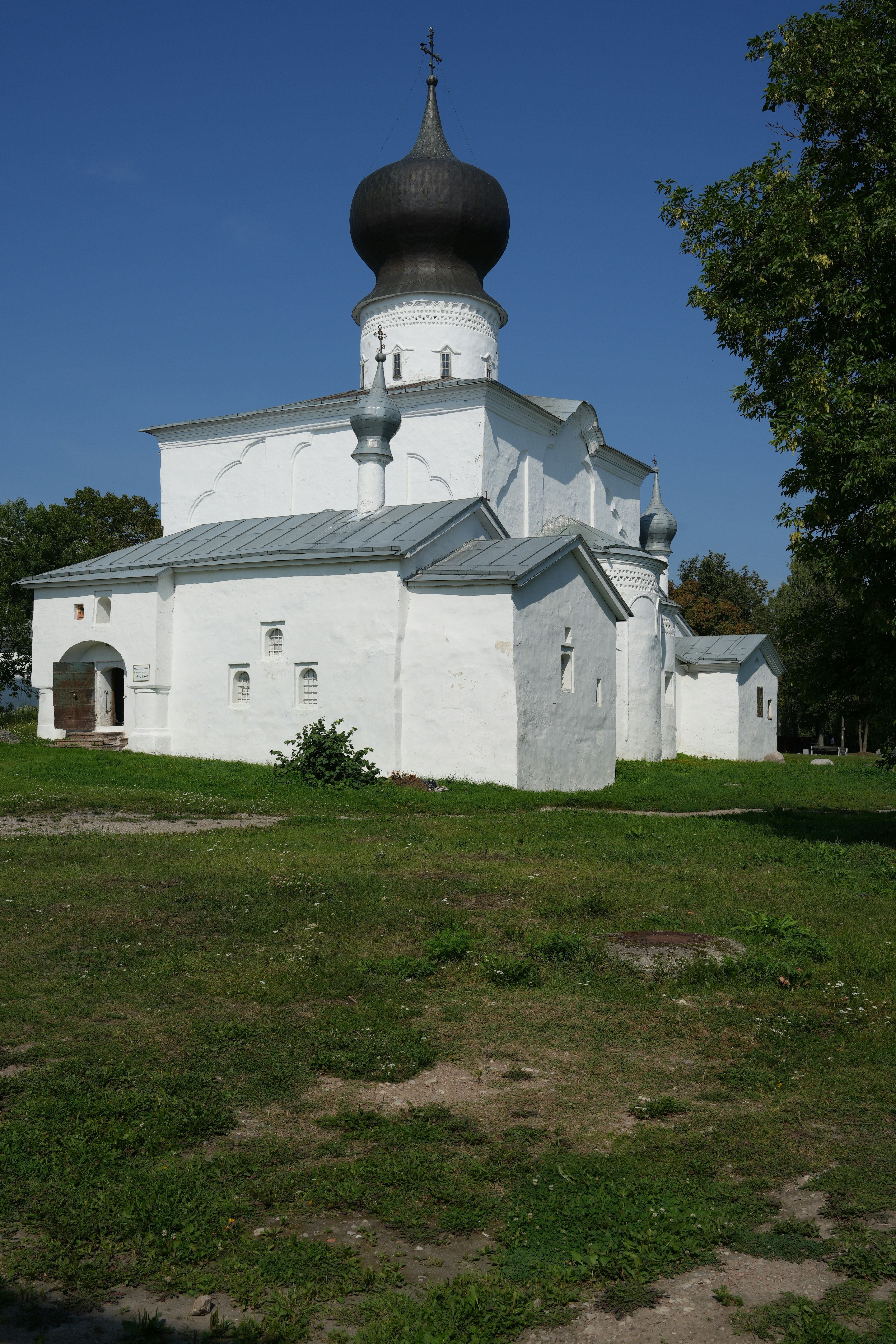 White church with dark dome under blue sky